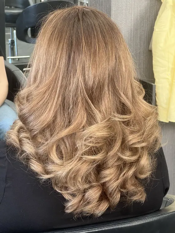 Honey blonde highlights finished with soft curls
