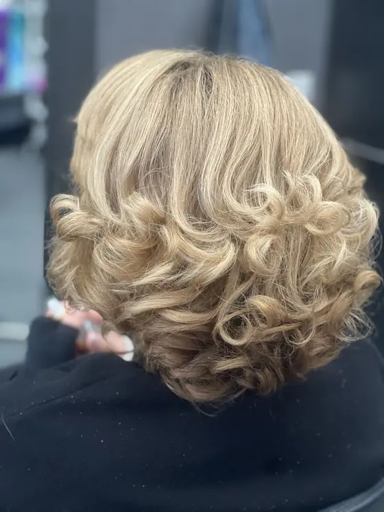Blonde curly updo with volume through the crown