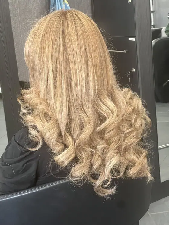 Long blonde highlights with a curled finish