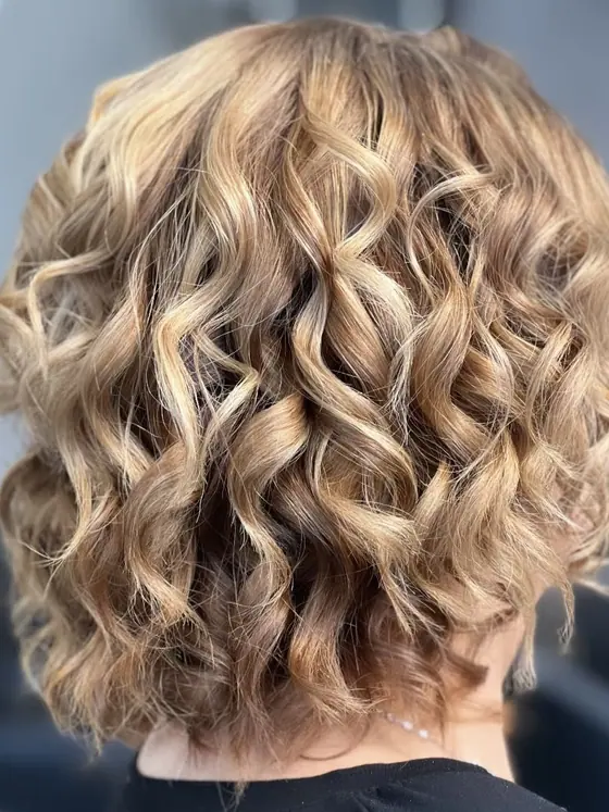 Blonde curly bob shaped around the jawline